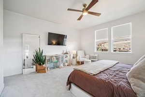 Carpeted bedroom with ceiling fan and baseboards