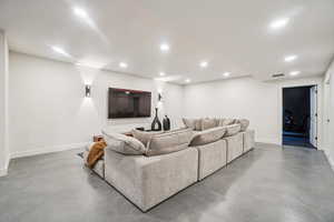Living area with finished concrete floors and baseboards
