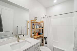 Full bathroom with shower / tub combo and vanity