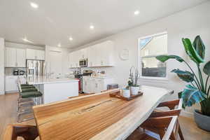 Dining room with light wood-style floors and recessed lighting
