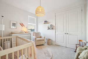 Bedroom with a crib and carpet floors
