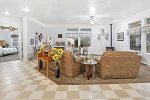Living room featuring a pellet stove, a ceiling fan, accent lighting, and light flooring