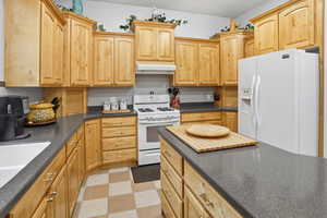 Kitchen with white appliances, a breakfast bar, and a kitchen island