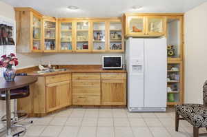 Kitchenette with a ceiling fan, light carpet, a textured ceiling, and plenty of natural light