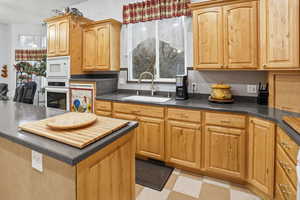 Kitchen with white appliances, a breakfast bar, and a kitchen island