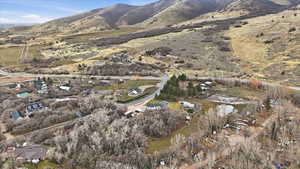 Aerial view of property and surrounding area featuring a mountain backdrop