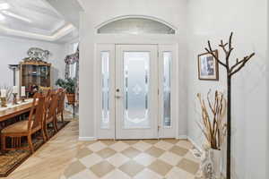 Entryway with a raised ceiling and light flooring