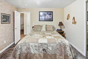 Bedroom with carpet flooring and a textured ceiling