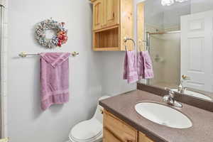 Main level 3/4 bathroom featuring vanity, toilet, and shower