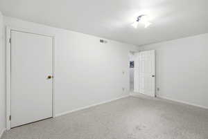 Unfurnished bedroom with carpet flooring and baseboards