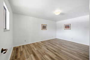 Spare room featuring wood finished floors and baseboards