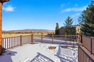 Snow covered deck featuring a mountain view