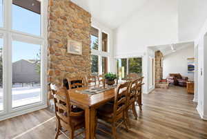 Dining room with high vaulted ceiling and light wood-type flooring