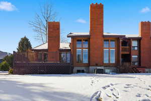 Rear view of property featuring a wooden deck and a chimney