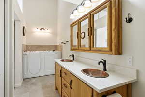 Full bathroom featuring double vanity and a garden tub