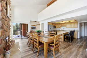 Dining space featuring a towering ceiling and light wood-type flooring