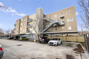 View of apartment building / complex with covered parking