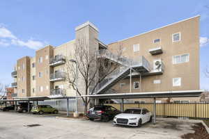 View of apartment building / complex with covered parking