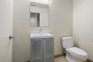 Half bath with vanity and light tile patterned floors