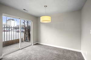 Carpeted spare room featuring baseboards and a textured ceiling