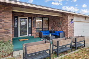 Porch featuring an outdoor living space and a garage