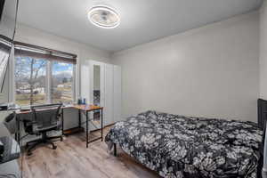 Bedroom with an office area and light wood-type flooring