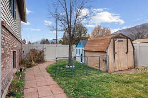 Fenced backyard with an outdoor structure and a mountain view