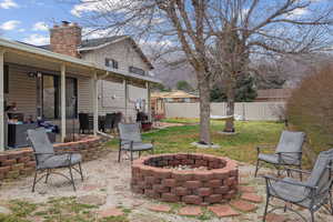 Fenced backyard featuring a fire pit and a patio area