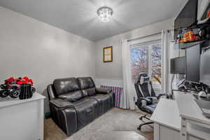 Office area featuring carpet flooring, a wainscoted wall, and a chandelier