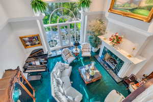 Living area featuring a high end fireplace and a high ceiling