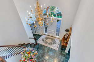 Entryway featuring a high ceiling and a chandelier