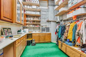 Kitchen with light countertops, brown cabinets, and dark colored carpet