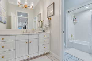 Bathroom with vanity, light tile patterned floors, bathing tub / shower combination, recessed lighting, and a chandelier