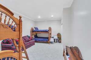 Carpeted bedroom with crown molding and recessed lighting