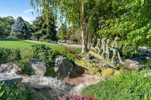 View of green lawn featuring view of wooded area