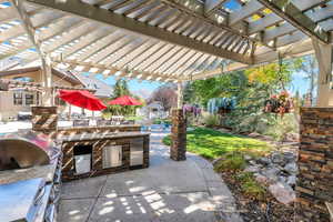 View of patio / terrace featuring exterior kitchen, a pergola, and outdoor dining space