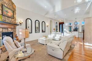 Living room featuring a fireplace, wood finished floors, and vaulted ceiling