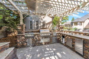 View of patio / terrace featuring an outdoor kitchen and a pergola