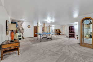 Game room featuring light colored carpet and a wood stove