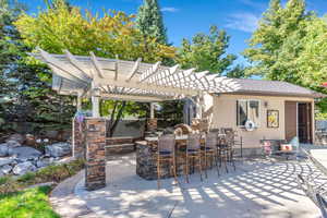 View of patio / terrace with area for grilling, pergola and pool house