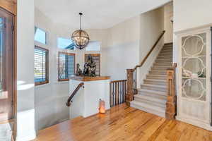 Entryway with hardwood flooring, a chandelier, and stairway