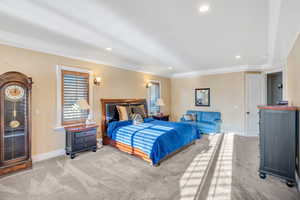 Primary suite bedroom with recessed lighting and crown molding