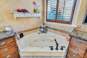 Full bathroom featuring a whirlpool tub and vanity