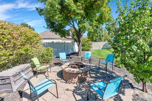 Fenced backyard with a patio and a fire pit