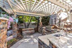 View of patio featuring area for grilling and a pergola