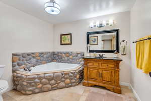 Full bath featuring vanity and a garden tub