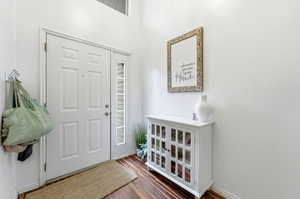 Entryway with dark wood-type flooring and baseboards