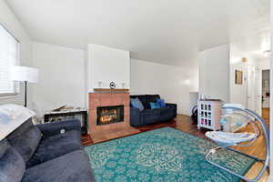 Living room featuring a tiled fireplace and dark wood-type flooring