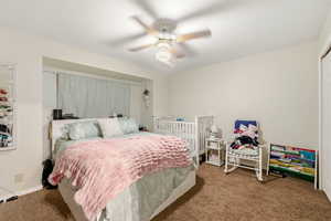 Bedroom featuring carpet floors, ceiling fan, and a closet