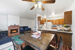 Dining room with a tile fireplace and a ceiling fan